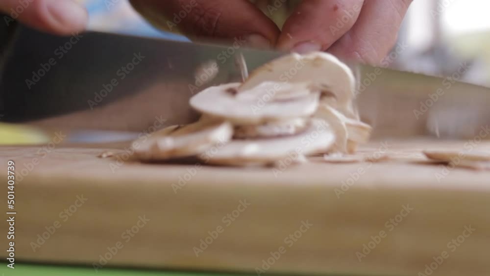 Cortar champiñones en una tabla de madera