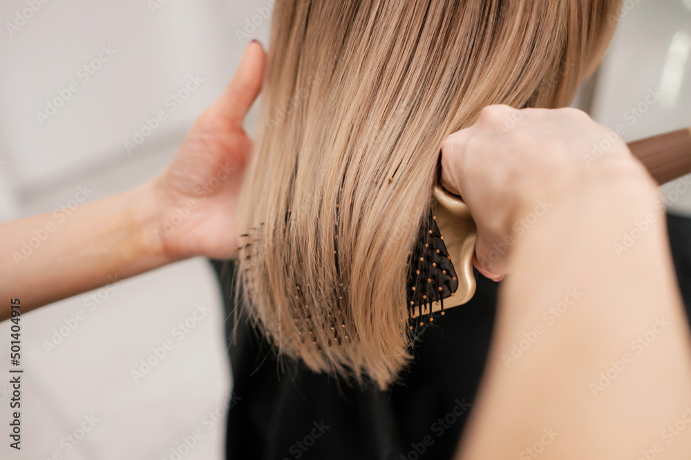 Fototapeta premium Hairdresser drying and combing hair