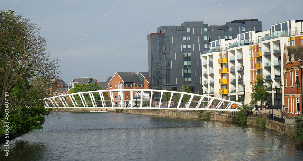 Footbridge over the River Great Ouse at Bedford with trees and modern buildings.