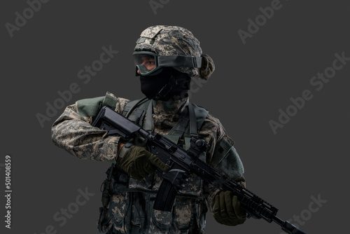 Fotografie, Obraz Shot of special force soldier holding rifle dressed in camouflage clothes and vest