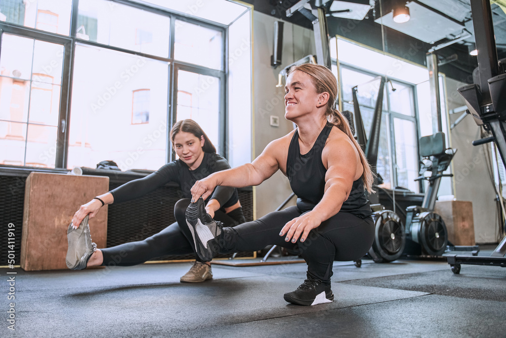 Woman with achondroplasia disorder sitting at the one leg and doing exercises Woman with achondroplasia disorder sitting at the one leg and doing exercises