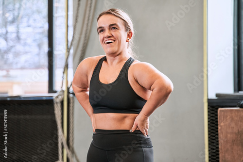Cheerful woman with autosomal disorder relaxing after workout at the gym photo