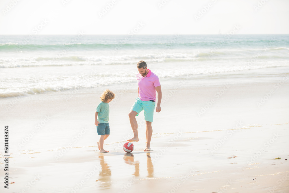 sport activity. father and son play football on beach. daddy with kid boy sport activity. father and son play football on beach. daddy with kid boy