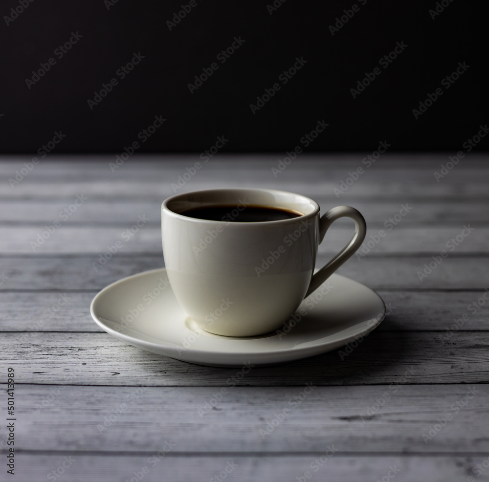 A cup of coffee, tea on a wooden table on black background A cup of coffee, tea on a wooden table on black background