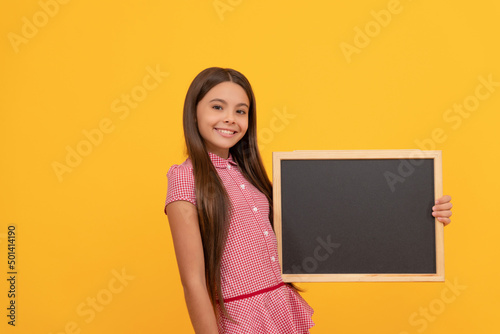 cheerful teen girl hold blackboard. child advertising. back to school.