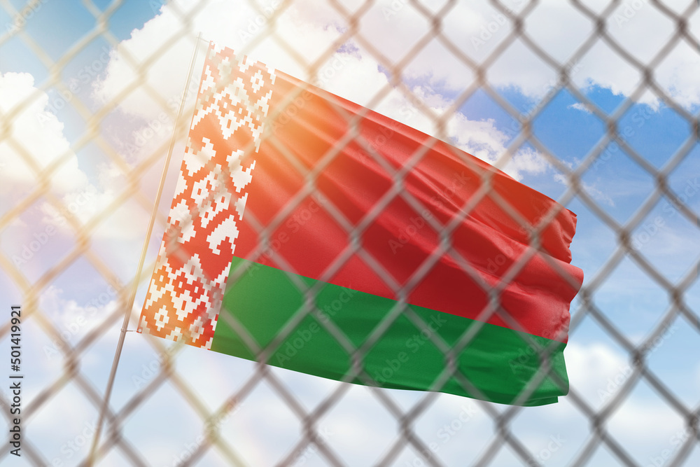 A steel mesh against the background of a blue sky and a flagpole with the flag of belarus A steel mesh against the background of a blue sky and a flagpole with the flag of belarus
