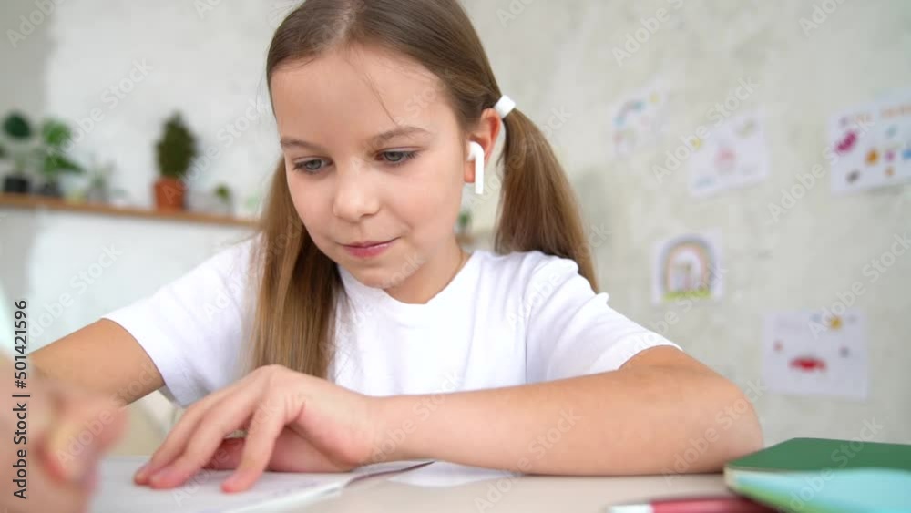 Remote school lessons. Child smiles studies and gets knowledge remotely. Little girl study online at home does homework. Distance learning education. Quarantine and Social distancing concept. Remote school lessons. Child smiles studies and gets knowledge remotely. Little girl study online at home does homework. Distance learning education. Quarantine and Social distancing concept.