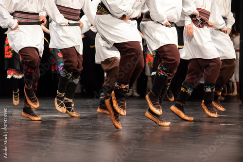 Serbian tradition dancers playing on annual concert. Folk Dancers from Serbia on the stage. Serbian folklore.
