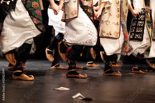 Serbian tradition dancers playing on annual concert. Folk Dancers from Serbia on the stage. Serbian folklore.
