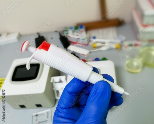Hand holding micro pipette in laboratory. Microliter Pipette.