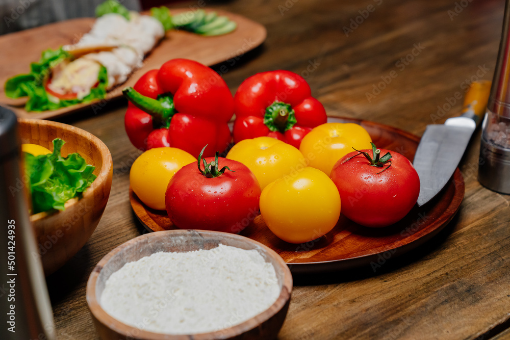a wooden utensil with flour and vegetables on the kitchen table. a wooden utensil with flour and vegetables on the kitchen table.