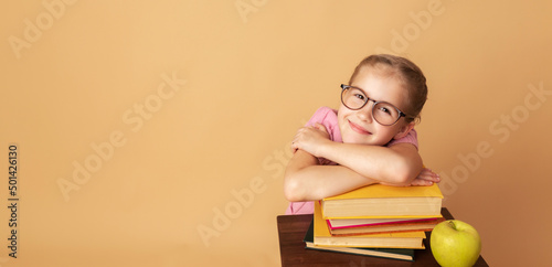 Pretty little girl schoolgirl with books and apple. School concept. Back to School. World books day