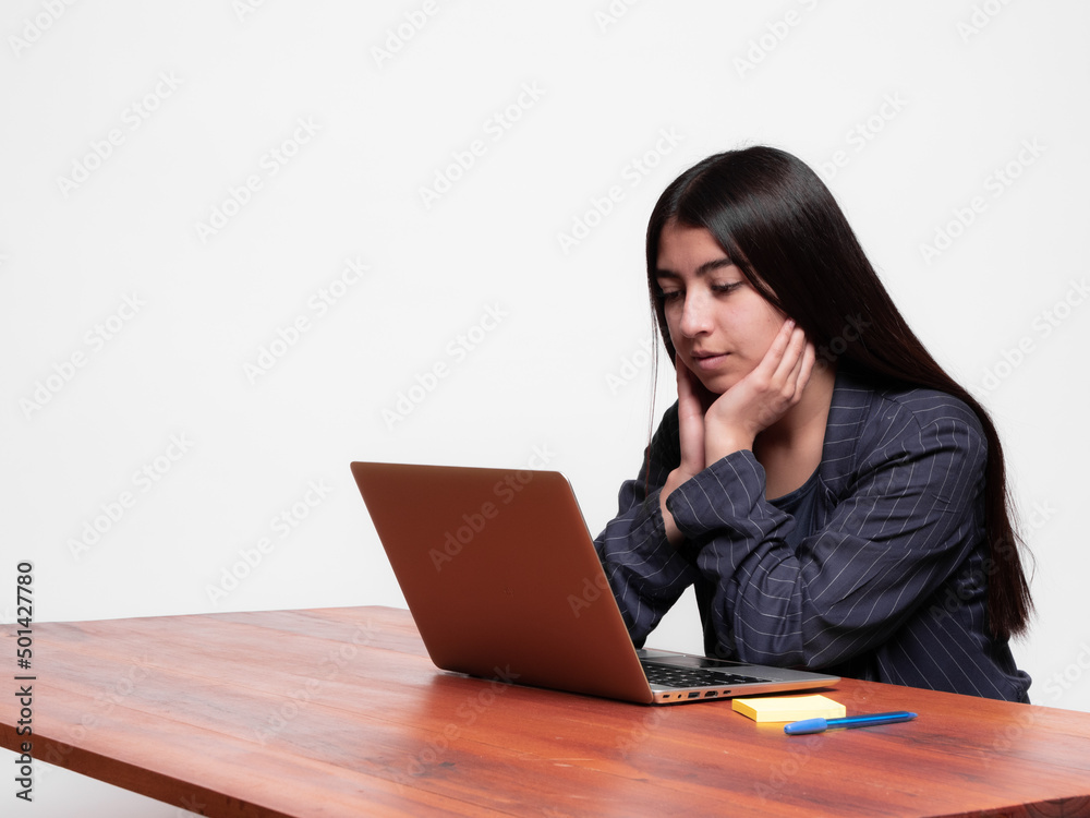 Hispanic businesswoman isolated on white background looking at a computer with bored attitude, concept of bored student Hispanic businesswoman isolated on white background looking at a computer with bored attitude, concept of bored student