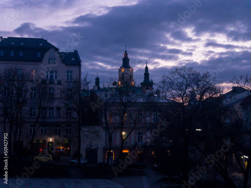 Twilight colours of night Przemysl at Poland at Wladycze street.  View is from museum of bells and tobacco pipes to the lights of bell tower and clock near Roman Catholic archicathedra in the Gothic 