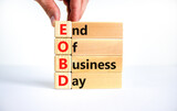 EOBD end of business day symbol. Concept words EOBD end of business day on wooden blocks on a beautiful white background. Businessman hand. Business EOBD end of business day concept.