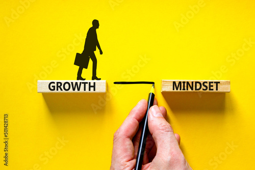 Growth mindset symbol. Wooden blocks with concept words Growth mindset on beautiful yellow background. Businessman icon. Businessman hand. Business growth mindset concept. Copy space.