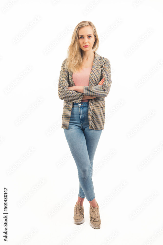 nice Cucasian blonde girl standing with arms crossed and looking into the camera seriously wearing sneakers denim jacket and pink shirt studio shot full shot white background copy space. High quality nice Cucasian blonde girl standing with arms crossed and looking into the camera seriously wearing sneakers denim jacket and pink shirt studio shot full shot white background copy space. High quality