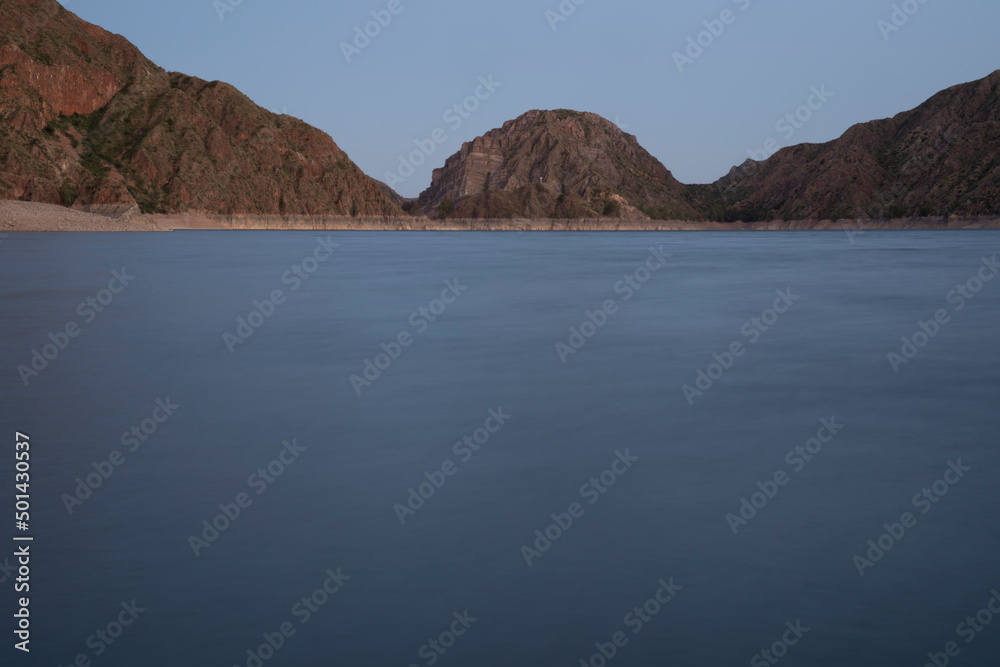 Magical view of the lake at night. Long exposure shot. View of the mountains and blurred water effect at nightfall.	