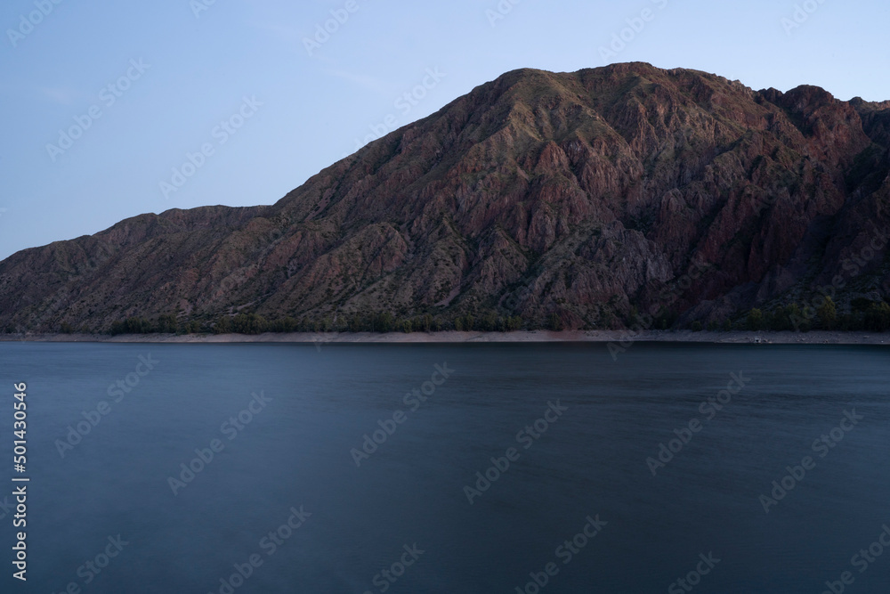 Long exposure shot of the lake and mountains at nightfall. Beautiful blurred water effect and color.