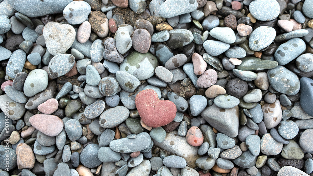 heart-shaped stone on a background of sea stones heart-shaped stone on a background of sea stones