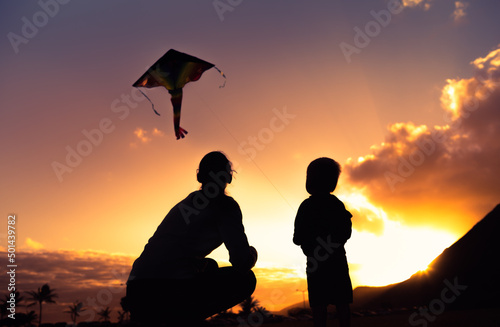 little boy and his mother flying kite.  Family parenting, and motherhood concept. 