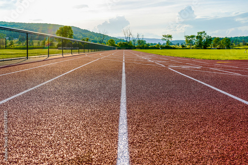 Image of new outdoor running track taken from a low perspective with clouds and hills in the background.
