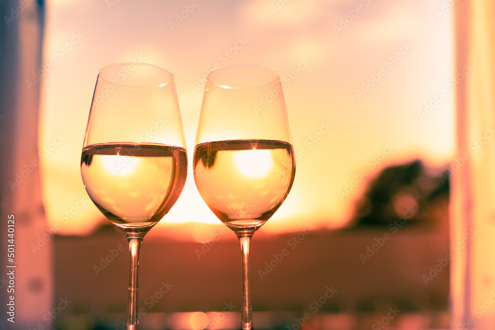 Pair on wine glasses in a beautiful sunset setting