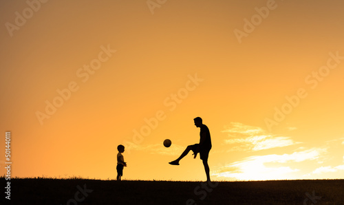 Father and son child playing soccer, football together. Fatherhood, and family active lifestyle concept.	