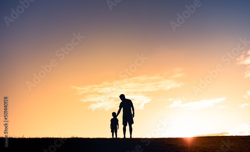 Silhouette of father and son waking together. Family parenting and raising a child concept. 