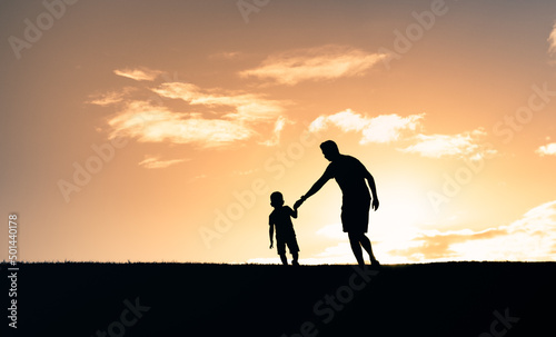 Father and son walking together in the sunset 