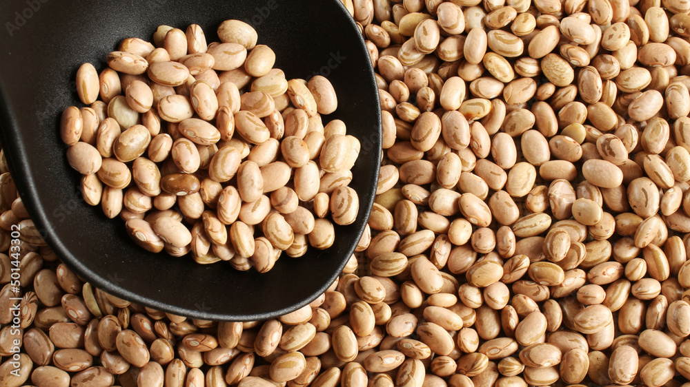 Ladle of carioca beans on the beans background.