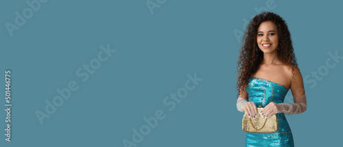 Elegant young African-American woman in beautiful dress and gloves on blue background with space for text
