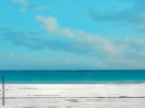 Empty wooden surface against blue sea and sky with clouds