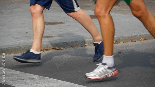 Slow motion running feet in a city marathon photo