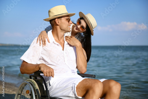 Young man with physical disability and his girlfriend at sea resort © Pixel-Shot