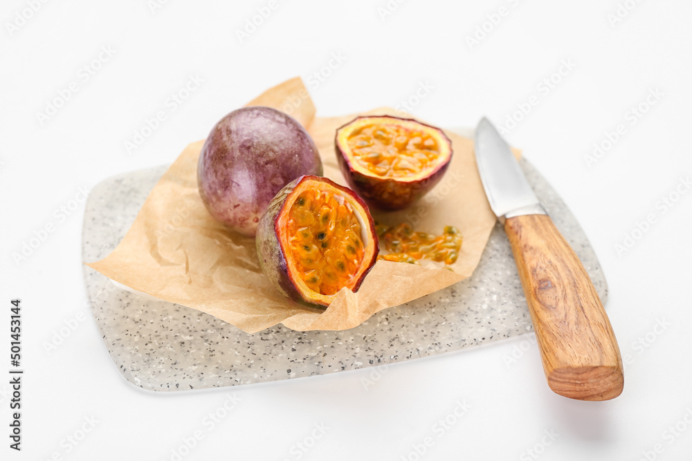 Board with delicious passion fruits and knife on white background Board with delicious passion fruits and knife on white background
