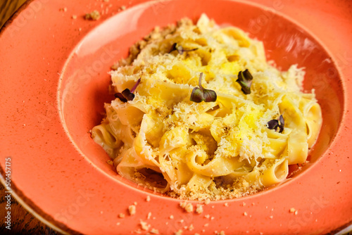 Italian recipe Pasta tortilloni with green pea, mint leaves, cheece, smoked bacon and cheese. Top view, blue background photo