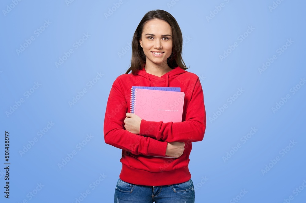 Obraz premium Smiling young student girl shows with books, confident in her knowledge, wearing shirt, white t-shirt