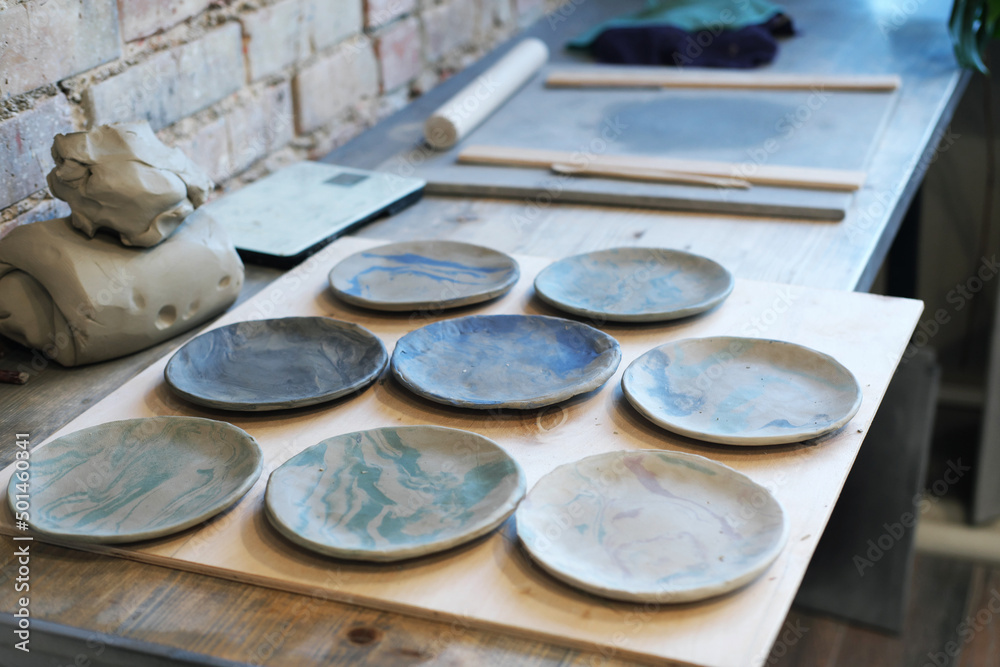 Unfinished clay pots on shelves as part of a ceramic pottery workshop. - obrazy, fototapety, plakaty 
