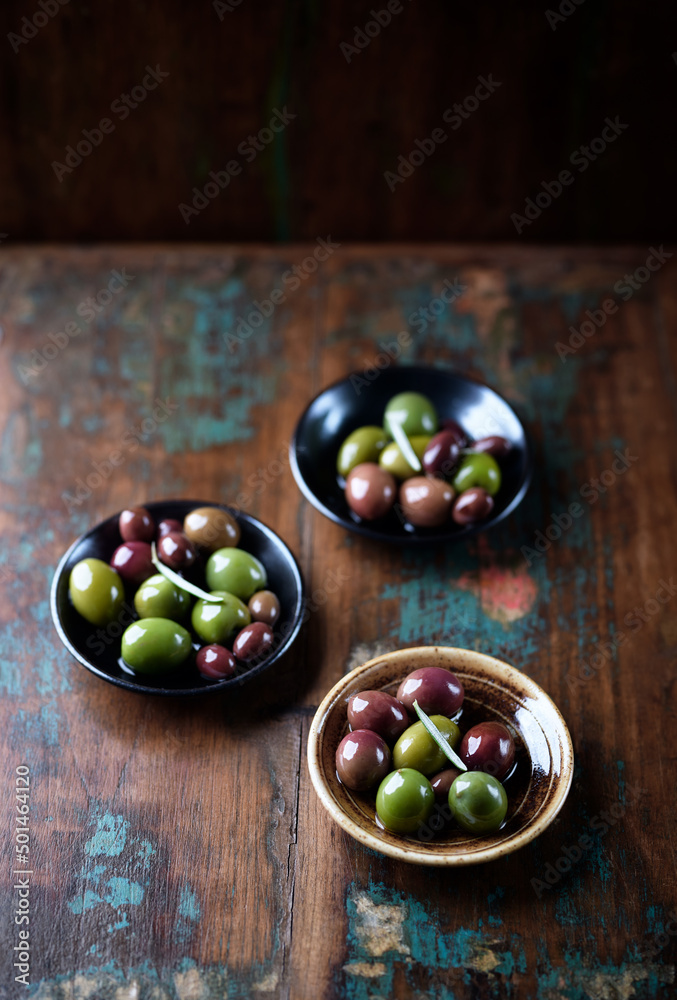 Various olives on rustic wooden background. Various olives on rustic wooden background.