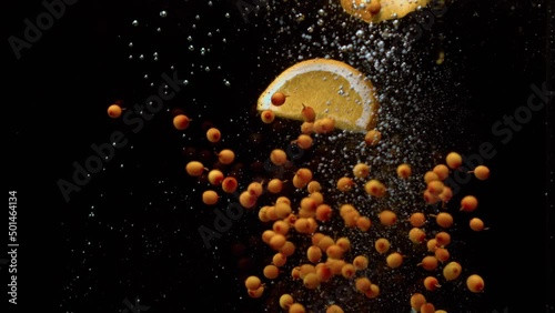 Sea buckthorn and lemon fall into the water.