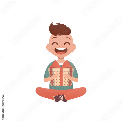 A little teen boy sits in a lotus position and holds a box with a bow in his hands. Birthday, New Year or holidays theme. Cartoon style isolated on white background.