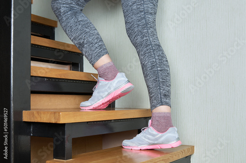 Sports woman legs in sport shoes on stairs
