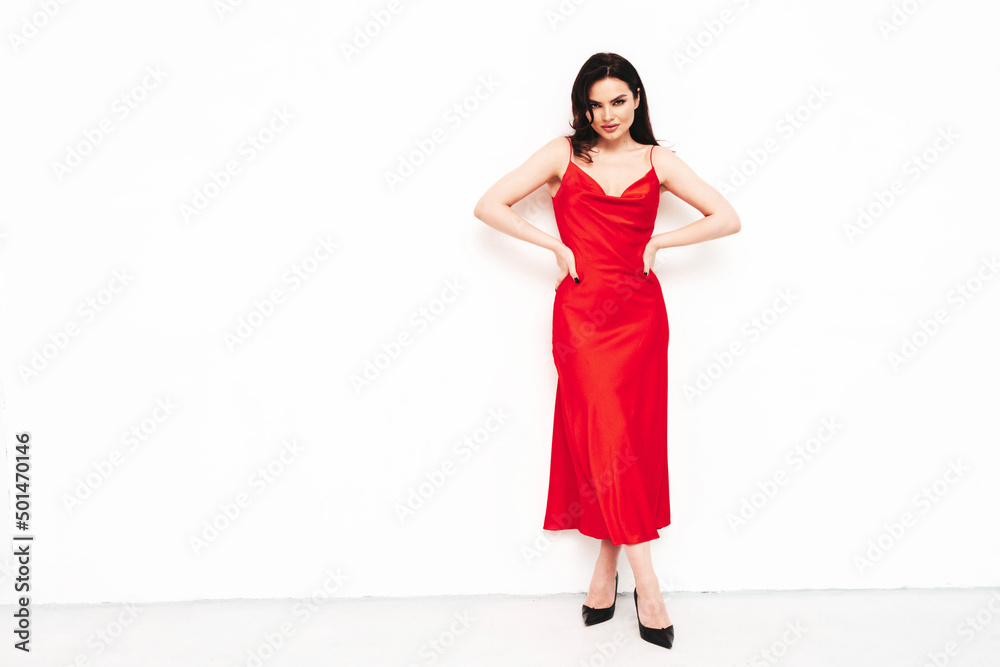 High fashion portrait of young beautiful brunette woman wearing nice trendy red evening dress. Sexy fashion model posing in studio. Fashionable female isolated on white High fashion portrait of young beautiful brunette woman wearing nice trendy red evening dress. Sexy fashion model posing in studio. Fashionable female isolated on white