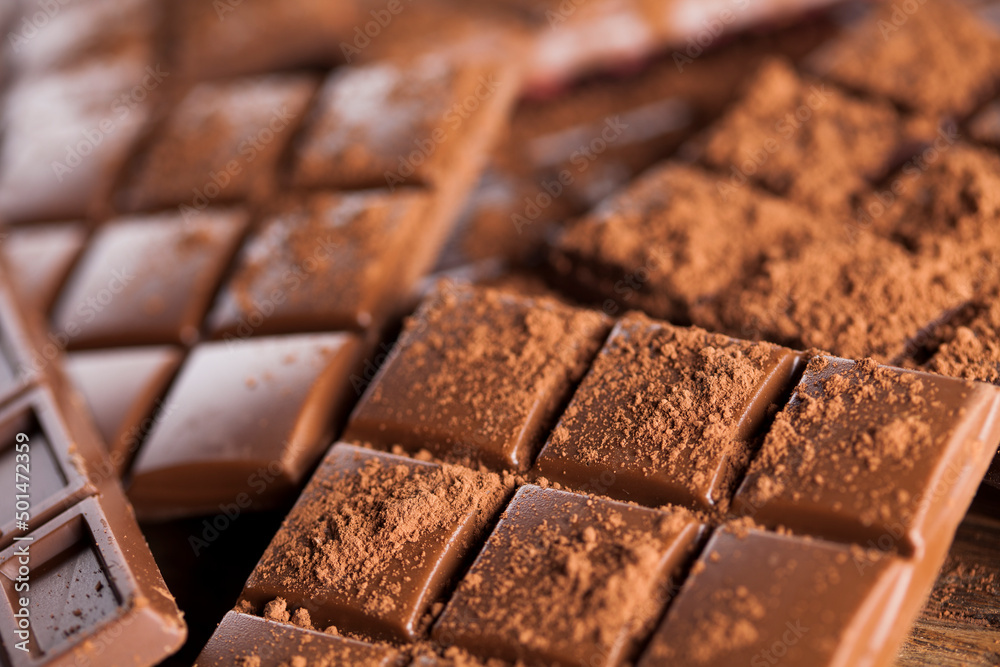 Dark homemade chocolate bars and cocoa pod on wooden Dark homemade chocolate bars and cocoa pod on wooden