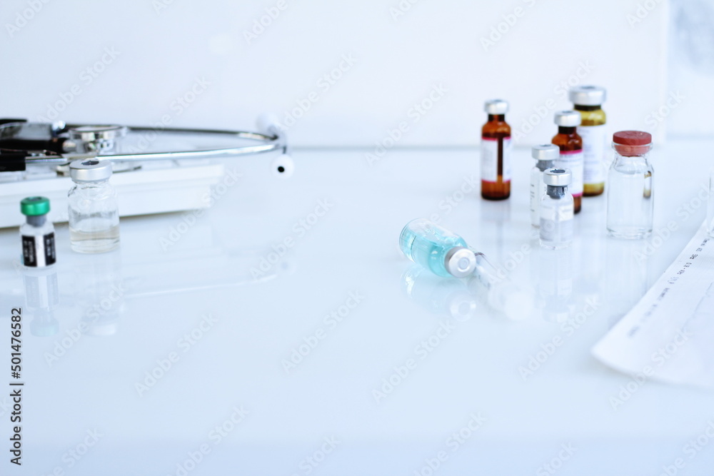 Vaccine bottle and syringe placed on a white table. Healthcare and medical concept. Vaccine bottle and syringe placed on a white table. Healthcare and medical concept.