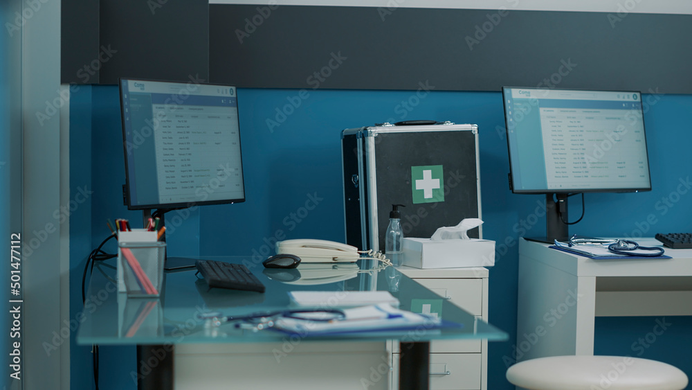 Empty desk in doctors office with computer and medical instruments. Nobody in cabinet used for consultation appointment and checkup visit where physician treats patients with disease.