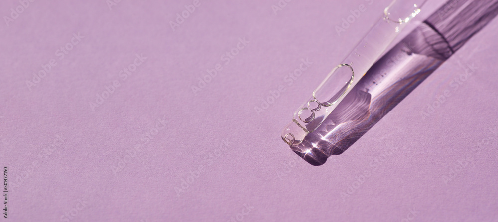 Pipette with serum or cosmetic liquid close-up on a lilac background in soft focus. Beautiful shadow in the sunlight. Skincare products , natural cosmetic. Beauty concept for face and body care Pipette with serum or cosmetic liquid close-up on a lilac background in soft focus. Beautiful shadow in the sunlight. Skincare products , natural cosmetic. Beauty concept for face and body care