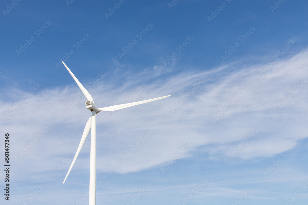 wind turbine in the wind with blue sky in background under sun light wind turbine in the wind with blue sky in background under sun light