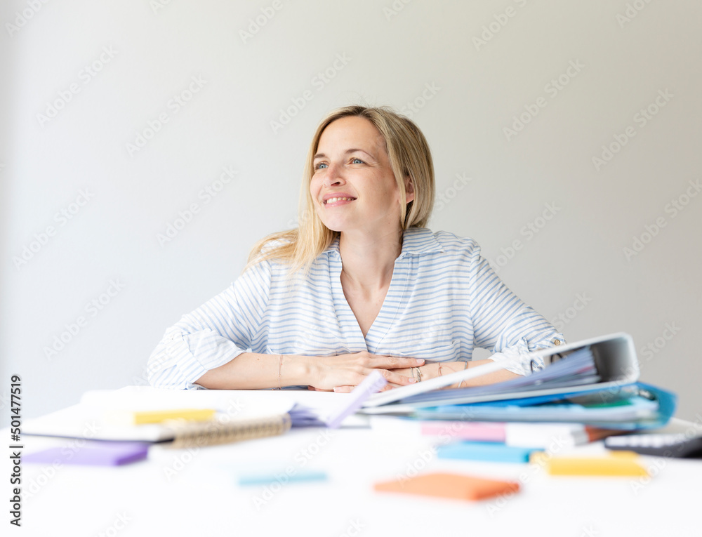 Businesswoman is sitting in bright modern office behind her desk on which many office things are lying and relaxing, sleeping and thinking Businesswoman is sitting in bright modern office behind her desk on which many office things are lying and relaxing, sleeping and thinking